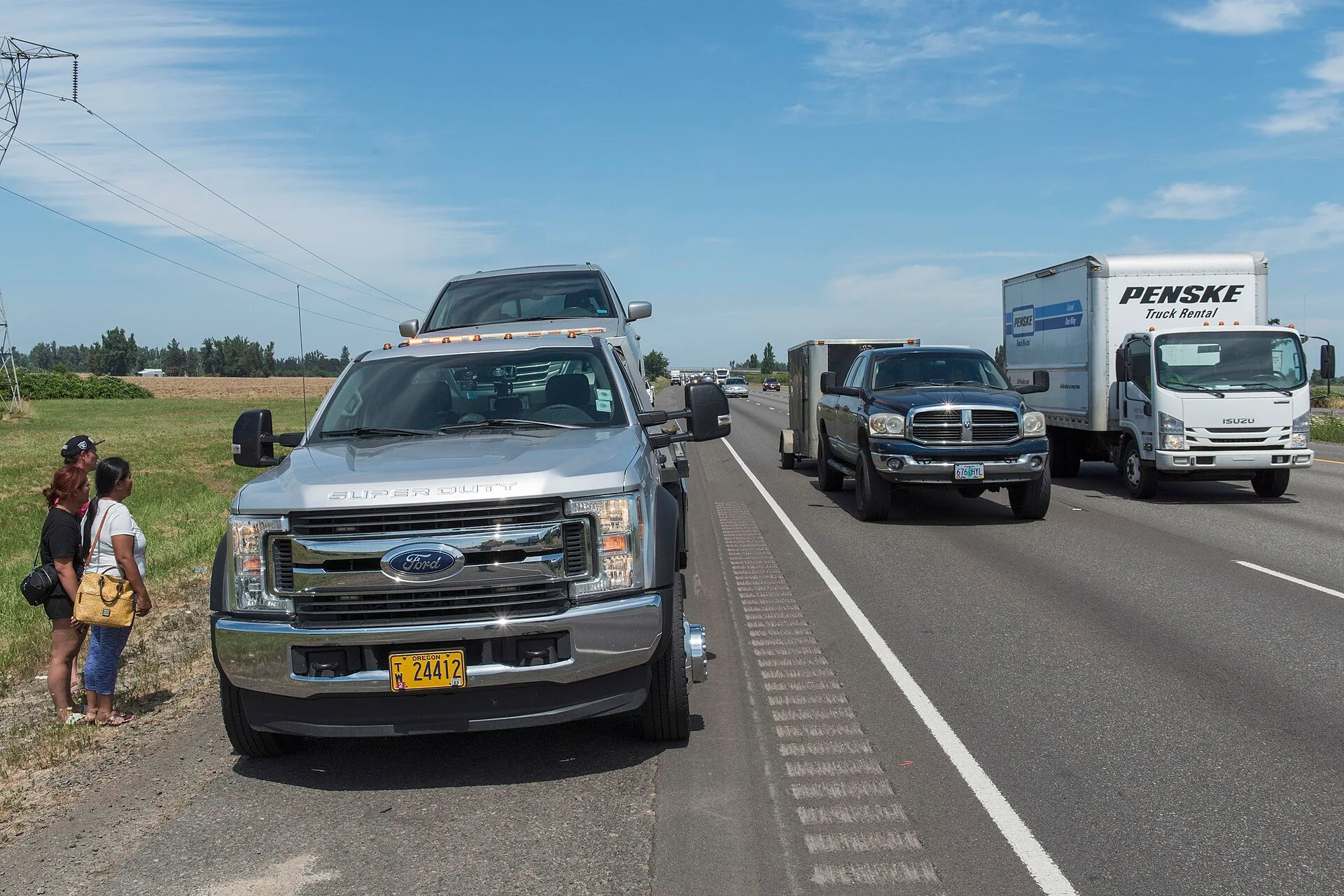 Sometimes, things happens. And driving down the highway with your family becomes more of an adventure than you anticipated. A tow truck assists a family on the shoulder of the highway. Waaay off behind them, an ODOT incident responder adds a layer of safety, letting traffic know there's an incident. How FMCSA rules shape American tow truck operations