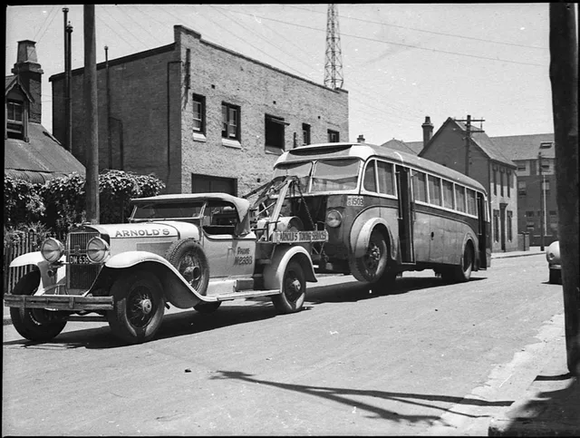 A Bedford Motor bus being towed to Queensland by Arnold's Towing Services using a 1929 Cadillac tow truck, 1 December 1938, by Sam Hood, from nitrate negative, State Library of New South Wales, Home and Away - 19462. What IRS Form 1099-NEC means for American tow truck owner-operators