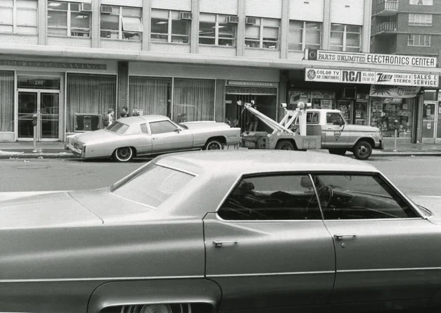 Black and white photo of vintage cars with a tow truck in an urban street setting. Towing company quote template: fields and line items