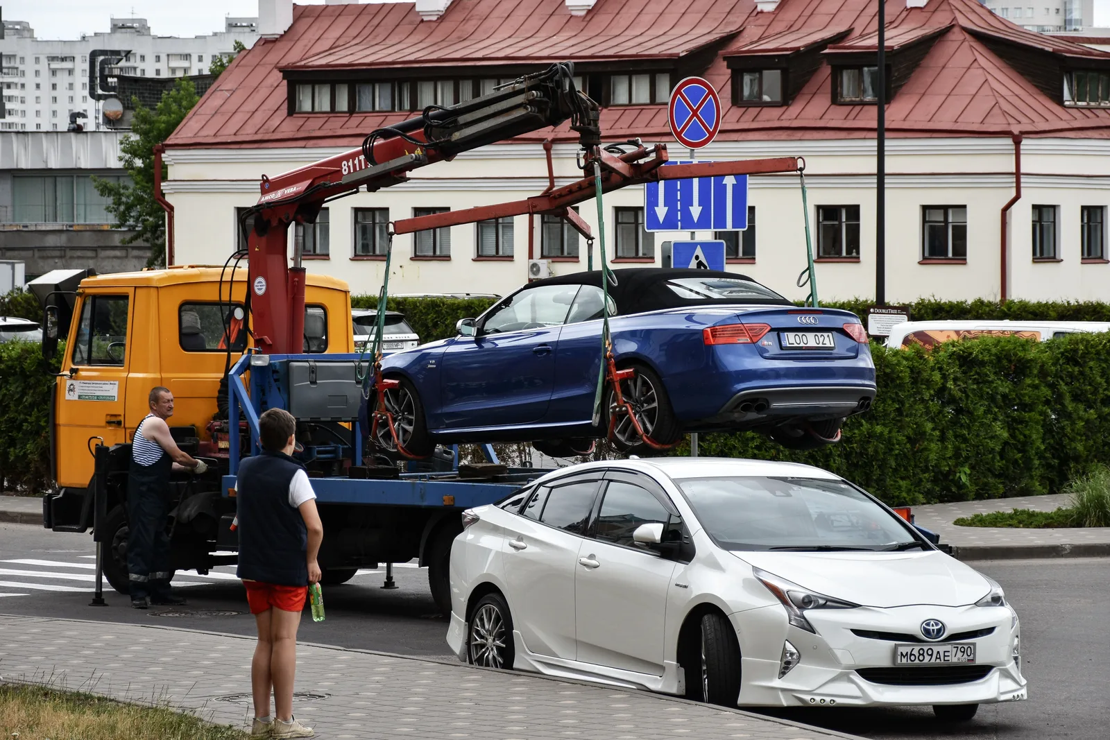Towing a blue Audi convertible in a bustling city street. Towing company systems and KPIs for owners in 2027