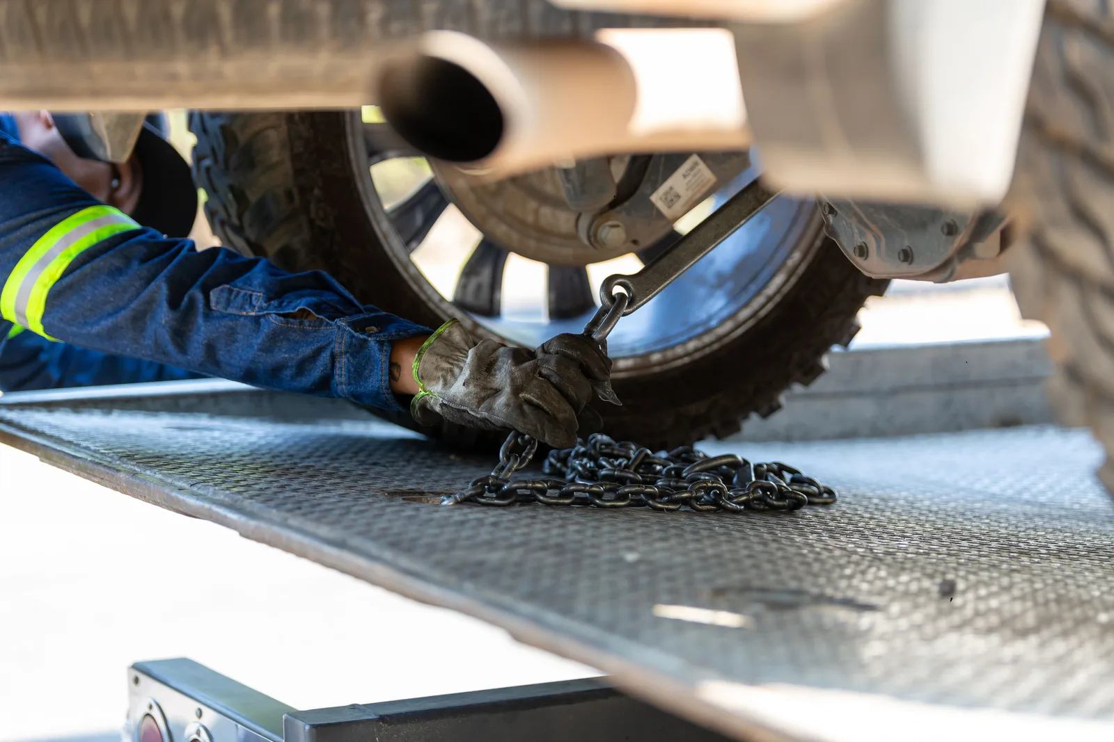 Mechanic securing a vehicle on a service platform with a chain for safe towing. The forces shaping towing company demand in 2027
