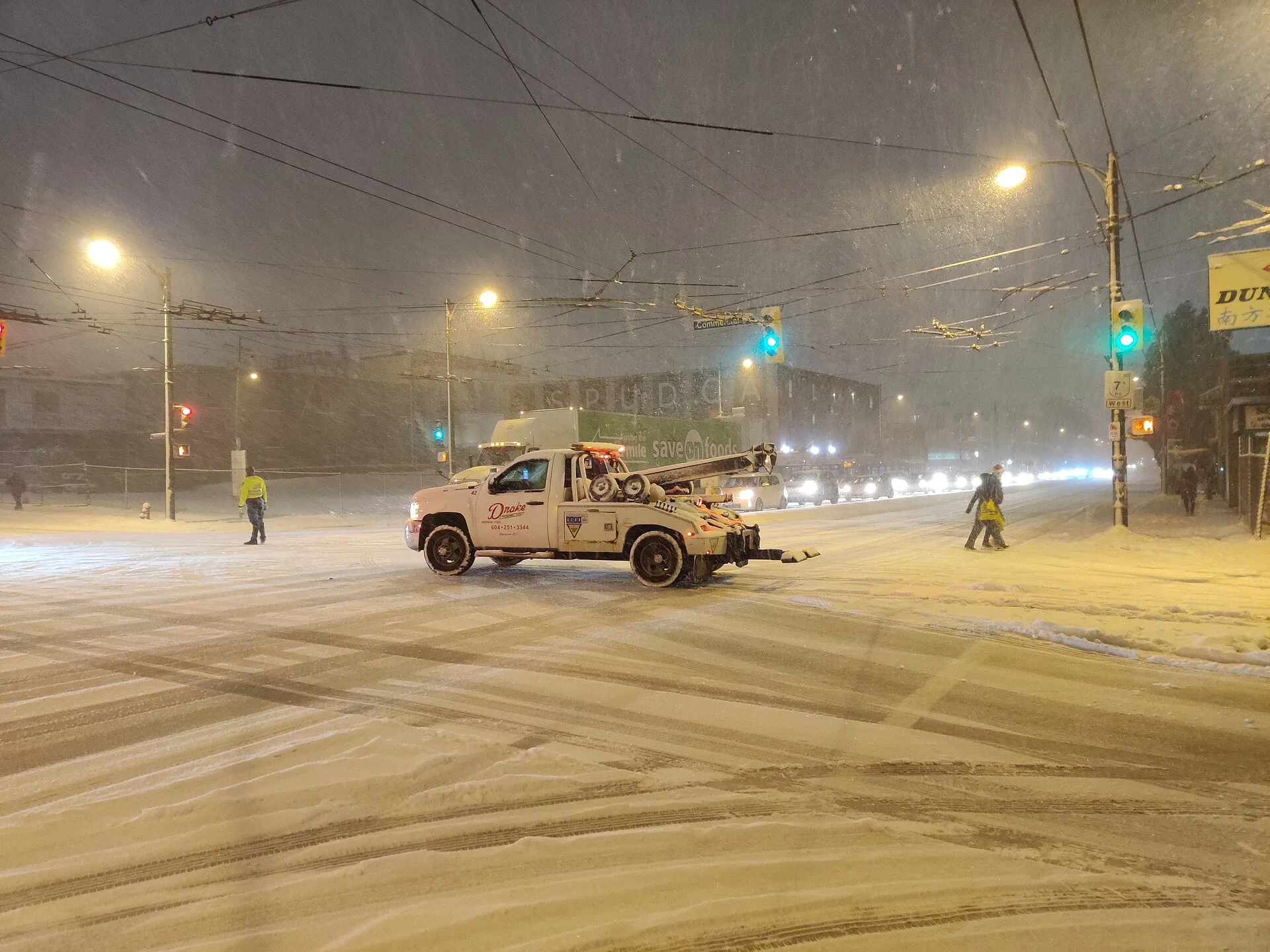 Towtruck during snowfall. Winter towing operations Canada: how cold is too cold
